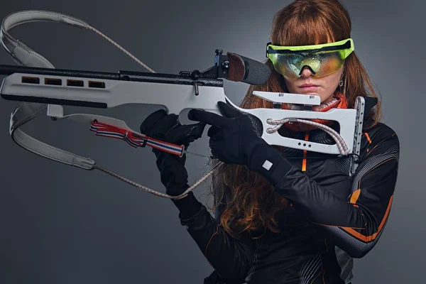 Redhead biatlon vrouwelijke sporters houdt competitief pistool. — Stockfoto