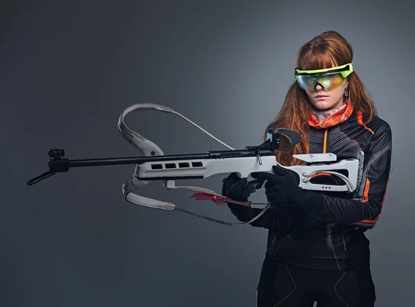 レッドヘッドビアトロン女性スポーツマンは競争力のある銃を保持しています. — ストック写真