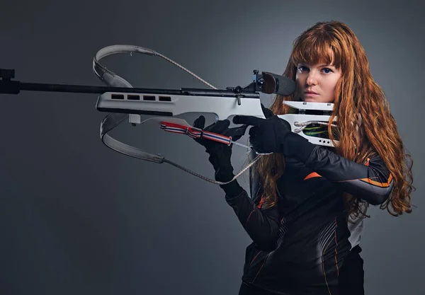 Ruiva campeã feminina Biathlon apontando com uma arma competitiva . — Fotografia de Stock