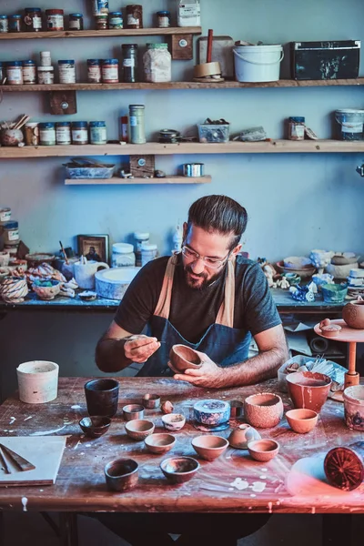 Talented artist at his own pottery studio is workig for new project.
