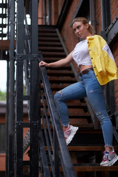 Freche Frau posiert auf Treppe zu eigener Wohnung für Fotograf. — Stockfoto