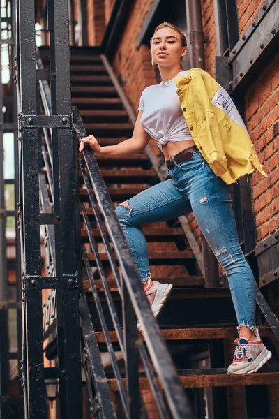 Bezczelna kobieta pozuje do fotografa na schodach do własnego mieszkania. — Zdjęcie stockowe