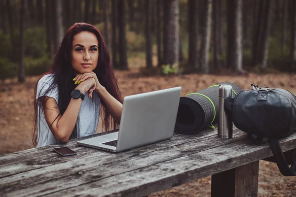 Vidám tanuló dolgozik a laptop az erdő közepén. — Stock Fotó