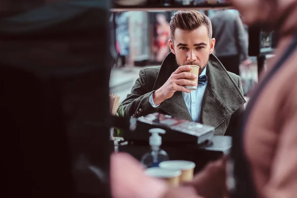 Hombre guapo arreglado está disfrutando de su café mientras está sentado en la cafetería — Foto de Stock