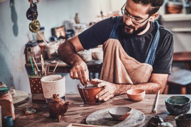 Pensive adam onun büyük yeni kil projesi üzerinde çalışıyor.