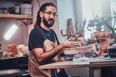 Gözlüklü çekici adam kendi kil projesi üzerinde çalışıyor.