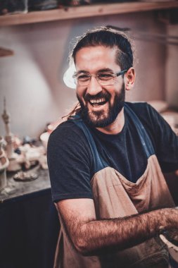 Gözlük karizmatik mutlu adam onun owh atölyesinde oturuyor ve onun projeleri onun etrafında.