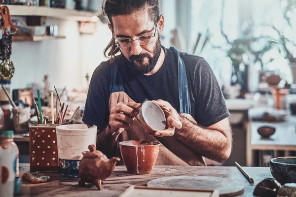 Полегшена приваблива людина кладе барвисту глину до свого нового горщика ручної роботи . — стокове фото