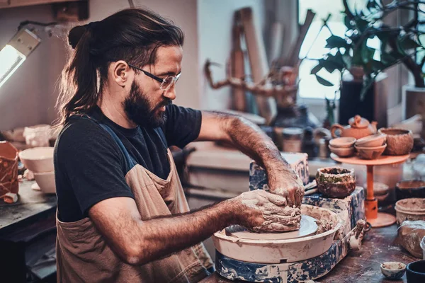 Atraktivní muž v brýlích pracuje na svém vlastním hliněném projektu. — Stock fotografie