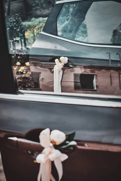 Closeup photo of decorater cars door with white roses and silk bow. — Stock Photo, Image