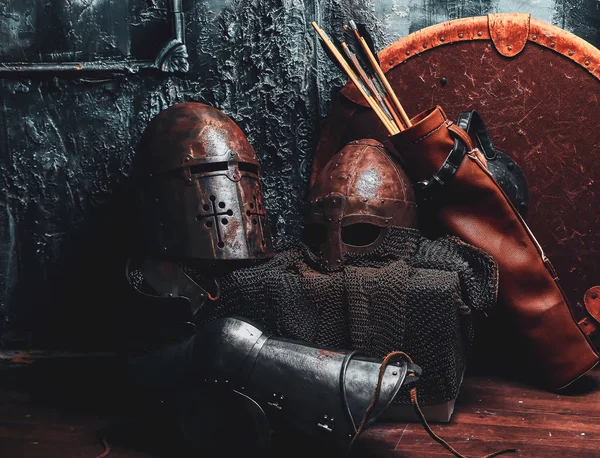 Still life with ancient shield, two rusted helmets, quiver of arrows — Stock Photo, Image