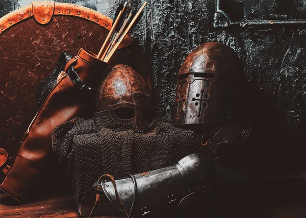 Bodegón con escudo antiguo, dos cascos oxidados, aljaba de flechas —  Fotos de Stock