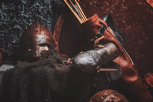 Bodegón con escudo antiguo, dos cascos oxidados, aljaba de flechas — Foto de Stock