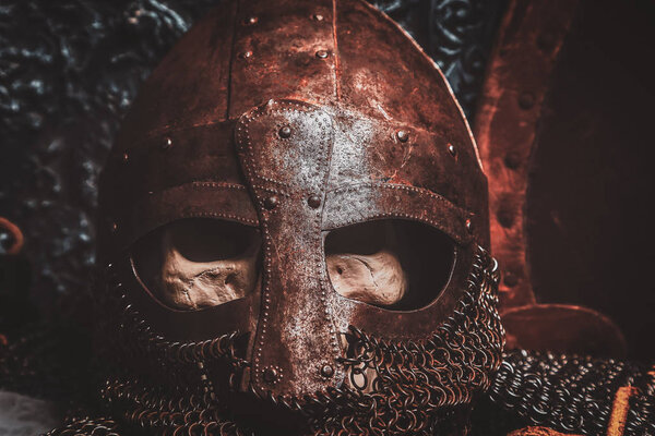 Ols rusted ancient helmet with human skull inside.