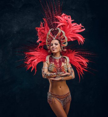Kırmızı tüy kostümgüzel brasil dansçı küçük sahnede dans ediyor.