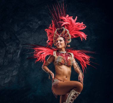 Kırmızı tüy kostümgüzel brasil dansçı küçük sahnede dans ediyor.