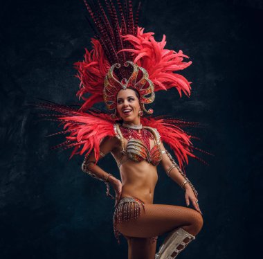 Kırmızı tüy kostümgüzel brasil dansçı küçük sahnede dans ediyor.