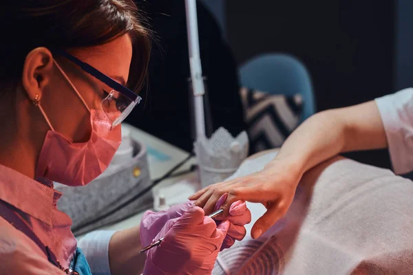 Manicura talentosa está trabajando en las uñas de los clientes —  Fotos de Stock