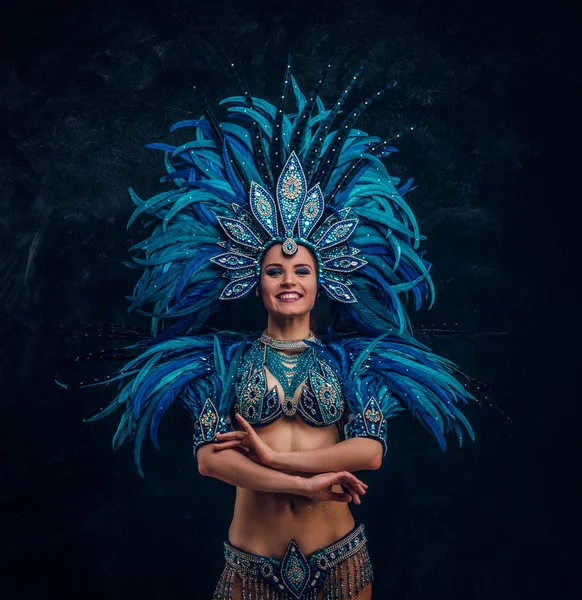 Beautiful brasil dancer is standing crosses her hands. She is wearing blue feather costume. — Stock Photo, Image