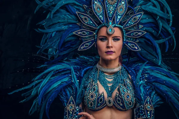Прекрасная бразильская танцовщица стоит, скрестив руки. На ней костюм голубого перья. . — стоковое фото