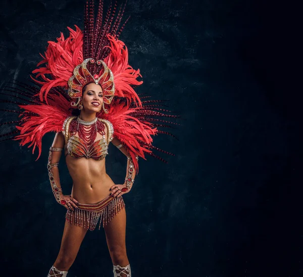 Beautiful brasil dancer in red feather costume is dancing on small scene. — Stock Photo, Image