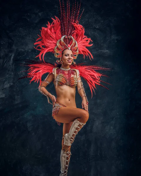 Kırmızı tüy kostümgüzel brasil dansçı küçük sahnede dans ediyor.