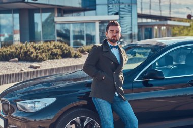 Bakımlı çekici adam park kendi araba üzerinde eğilerek