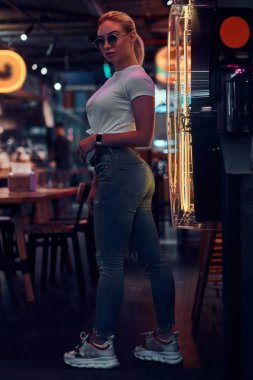 Neon barda güneş gözlüğü çekici kadın fotoğrafçı için poz.