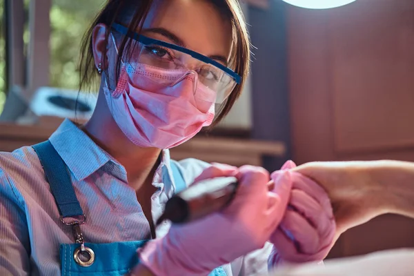 Giovane manicure sta lavorando sul suo posto di lavoro con il cliente . — Foto Stock