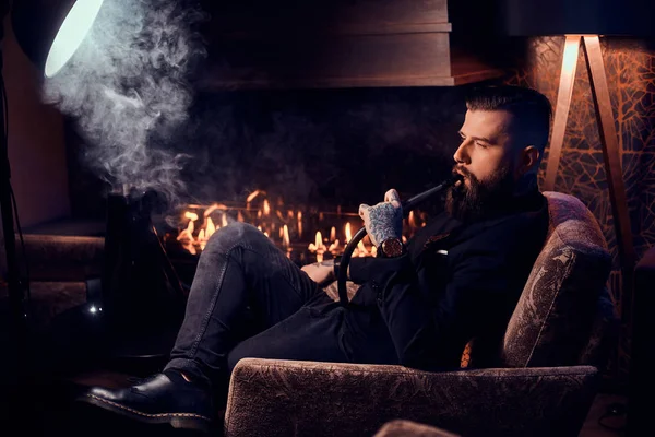Elegante homem inteligente é relaxante e fumar narguilé depois de longo dia difícil — Fotografia de Stock