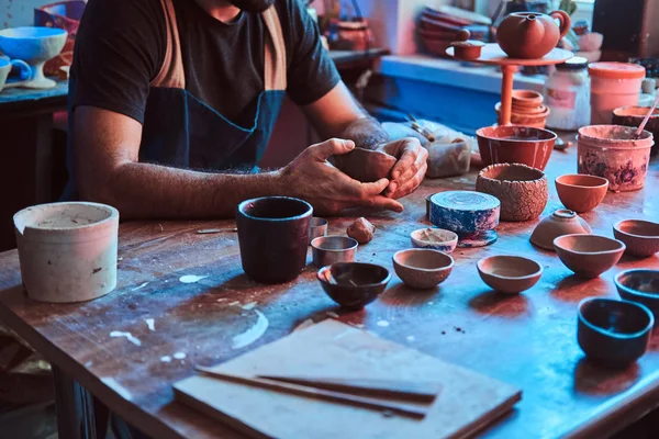 Alfarero pensativo en vasos en su propio taller es workig en una nueva tetera hecha a mano . —  Fotos de Stock