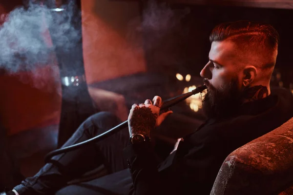 英俊的胡子男子是放松在休息室，而吸烟钩 — 图库照片