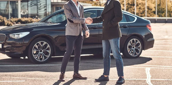 Foto de dos hombres elegantes inteligentes, que tienen un trato sobre el coche . — Foto de Stock