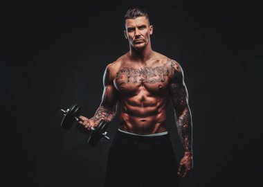 Kaslı biri dumbbells ile yapıyor.