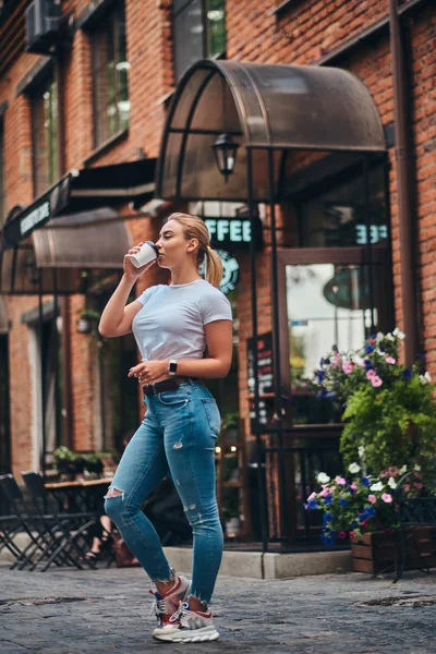 Mladá žena s odnášejícím šálek kávy je těší léto venku. — Stock fotografie