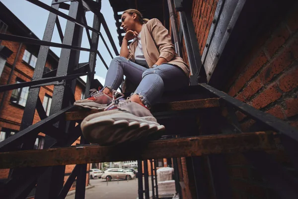 Lage hoek foto van brutale vrouw in zonnebril en denim op achtertuin. — Stockfoto