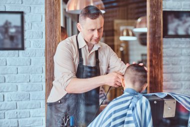 Komik küçük çocuk firs zamanda moda kuaför salonunda expirienced berber trendy saç kesimi oluyor