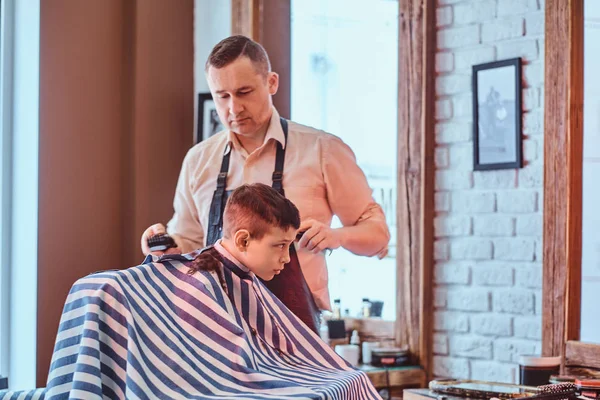 Small school boy had his first trendy haircut at modern barbershop. — Stock Photo, Image