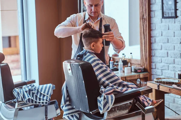 Kis iskolás fiú egyre trendi fodrász a expirienced Borbély a modern Barbershop — Stock Fotó