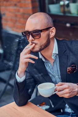 Pensive adam kafe dışında kahve ve sigara içiyor