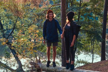 Romantik mutlu yürüyüşçüler yeşil yemyeşil ormanda gün batımını izliyor