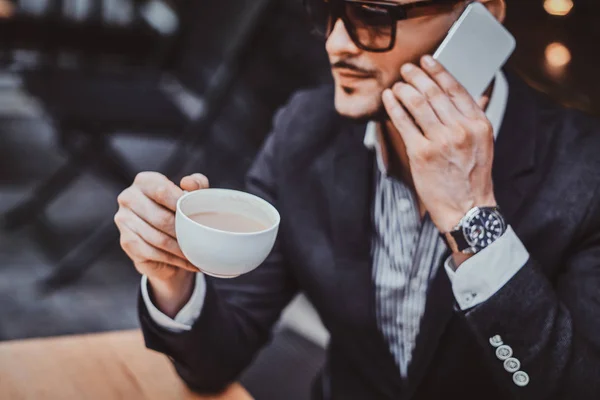 Grave uomo di successo sta chiamando da cellulare e godersi il suo caffè . — Foto Stock