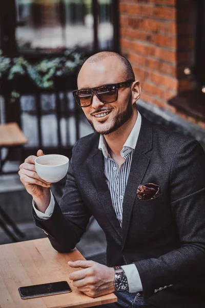 Feliz hombre sonriente está bebiendo café — Foto de Stock