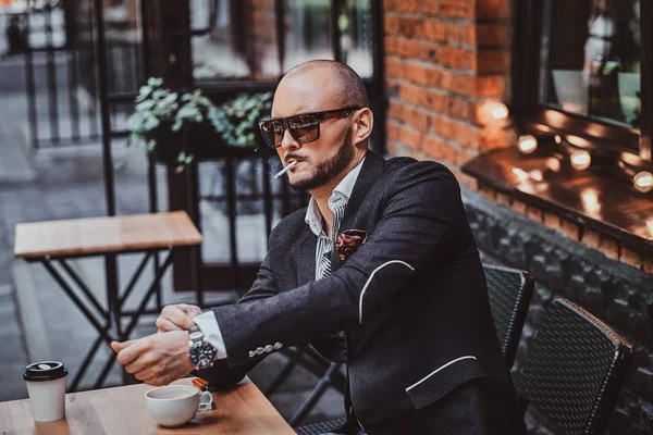 El hombre pensativo está tomando café y fumando fuera de la cafetería — Foto de Stock