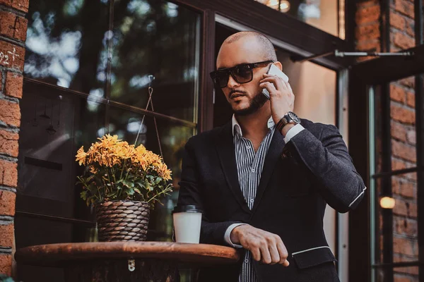 El exitoso hombre de negocios está hablando por teléfono mientras está sentado en coffeeshop . —  Fotos de Stock