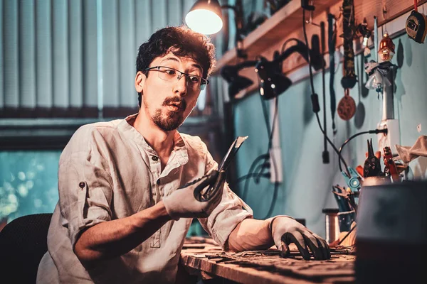 Joyeux artisan dans son atelier de restauration avec des plis et la paix du verre dans ses mains . — Photo