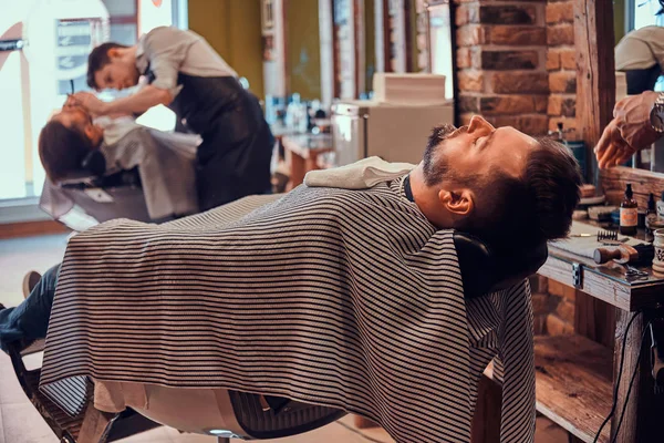 Peluquería de moda en la barbería moderna está trabajando en los clientes corte de pelo . — Foto de Stock