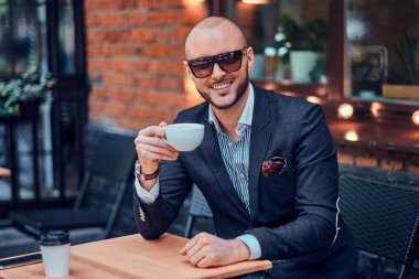 Mutlu gülümseyen adam kahve içiyor