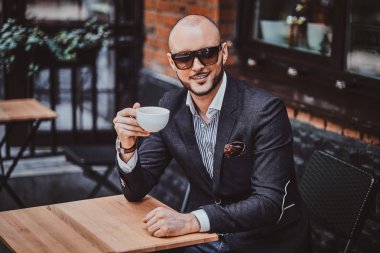 Mutlu gülümseyen adam kahve içiyor