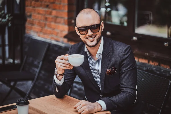 Feliz hombre sonriente está bebiendo café —  Fotos de Stock